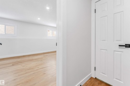 The room features light wood flooring, white walls, and recessed lighting - 10865 21 Ave, Edmonton, AB - Indoor Photo Showing Other Room
