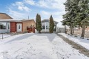 The property features a front yard with a paved walkway and mature evergreen trees - 10865 21 Ave, Edmonton, AB  - Outdoor 