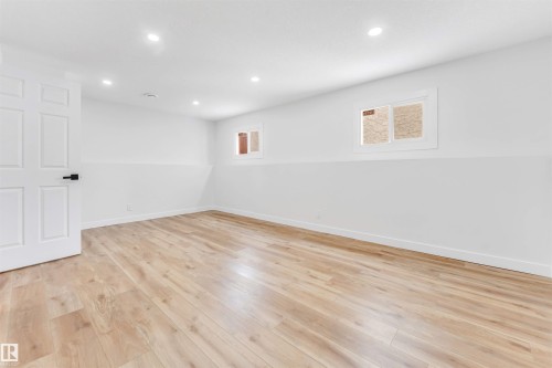This room features light-toned wood flooring, white walls, and recessed lighting - 10865 21 Ave, Edmonton, AB - Indoor Photo Showing Other Room