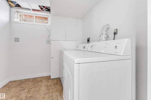 The laundry room features white walls, a window with security bars, and a white washer and dryer set - 10865 21 Ave, Edmonton, AB - Indoor Photo Showing Laundry Room