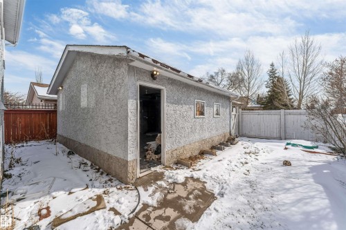 The property features a detached building with stucco siding and a partial door opening - 10865 21 Ave, Edmonton, AB - Outdoor
