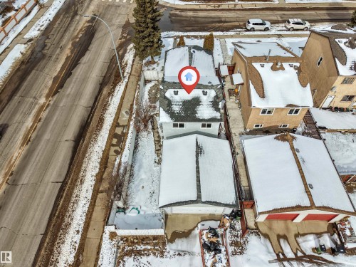 Aerial view of the property and surrounding neighborhood, featuring a paved street and residential homes - 10865 21 Ave, Edmonton, AB - Outdoor With View