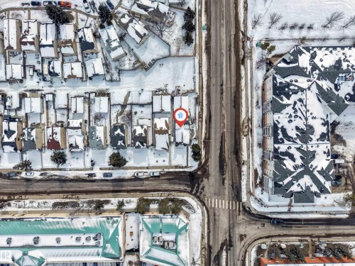 Aerial view showcasing the property within a neighborhood featuring streets, sidewalks, and surrounding structures - 10865 21 Ave, Edmonton, AB -  With View