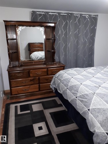 This room features hardwood floors and light gray walls - 5512 50Th Ave, Wetaskiwin, AB - Indoor Photo Showing Bedroom