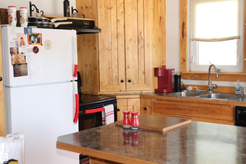 The kitchen features wooden cabinetry, a double basin sink, and a window with a roller shade - 5512 50Th Ave, Wetaskiwin, AB - Indoor Photo Showing Kitchen With Double Sink