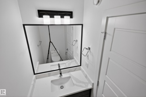 Modern bathroom vanity with a rectangular undermount sink, a chrome single-handle faucet, and a quartz countertop - 408 Crystal Creek Link, Leduc, AB - Indoor Photo Showing Other Room