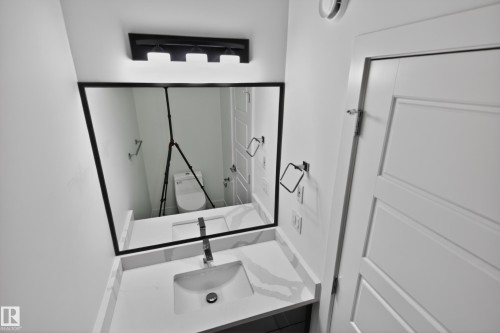 Vanity featuring a rectangular undermount sink, a chrome single-handle faucet, and a light-toned countertop - 408 Crystal Creek Link, Leduc, AB - Indoor Photo Showing Other Room