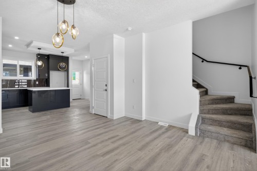 Open-concept living space with light-toned wood-finish flooring - 408 Crystal Creek Link, Leduc, AB - Indoor