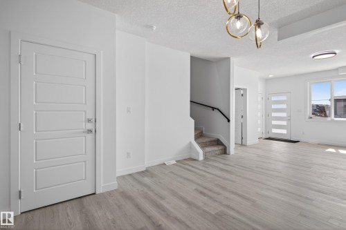 Open concept interior featuring wide plank wood-finish flooring - 408 Crystal Creek Link, Leduc, AB - Indoor Photo Showing Other Room
