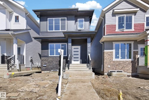 Contemporary two-story exterior featuring a stacked stone facade and horizontal siding - 408 Crystal Creek Link, Leduc, AB - Outdoor With Facade