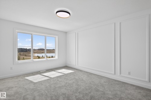 Expansive window framing a water feature and distant structures - 408 Crystal Creek Link, Leduc, AB - Indoor Photo Showing Other Room