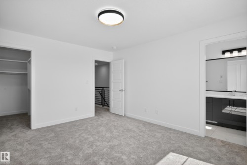 Carpeted room featuring a ceiling-mounted light fixture, white walls, and white trim - 408 Crystal Creek Link, Leduc, AB - Indoor Photo Showing Other Room