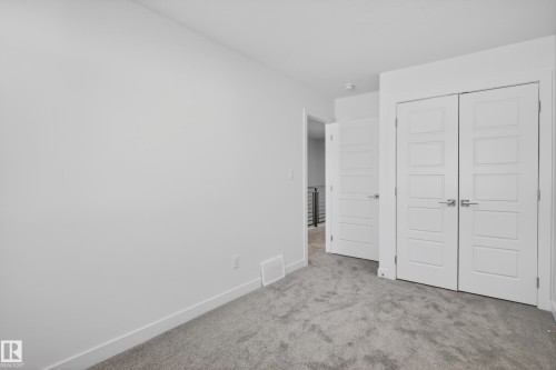 Spacious room featuring light gray carpeting and bright white walls - 408 Crystal Creek Link, Leduc, AB - Indoor Photo Showing Other Room