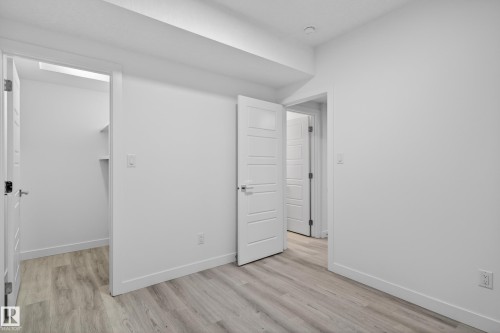 Room featuring white walls and wood-finish flooring - 408 Crystal Creek Link, Leduc, AB - Indoor Photo Showing Other Room