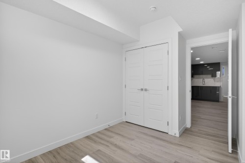 Room featuring light wood-finish flooring, white walls, and a closet with white panel doors - 408 Crystal Creek Link, Leduc, AB - Indoor Photo Showing Other Room