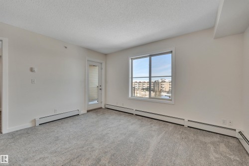 This room features light-colored walls and grey carpet flooring - 415 12035 22 Avenue, Edmonton, AB - Indoor Photo Showing Other Room