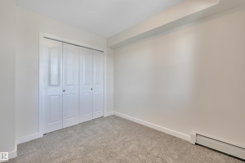 The room features light-colored walls and grey carpeting - 415 12035 22 Avenue, Edmonton, AB - Indoor Photo Showing Other Room