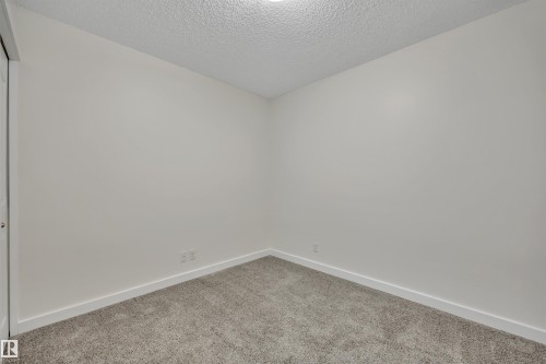 This room features newly installed gray carpet, crisp white walls, and a recessed ceiling light - 415 12035 22 Avenue, Edmonton, AB - Indoor Photo Showing Other Room