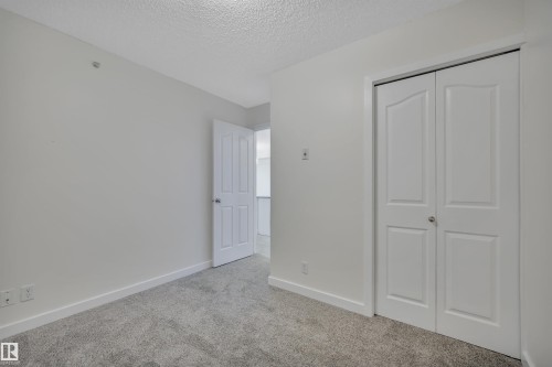 This room features light grey walls and grey carpet, creating a neutral palette - 415 12035 22 Avenue, Edmonton, AB - Indoor Photo Showing Other Room