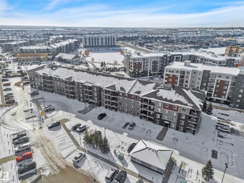 The property features a multi-story building with balconies, surrounded by paved parking areas - 415 12035 22 Avenue, Edmonton, AB - Outdoor With View