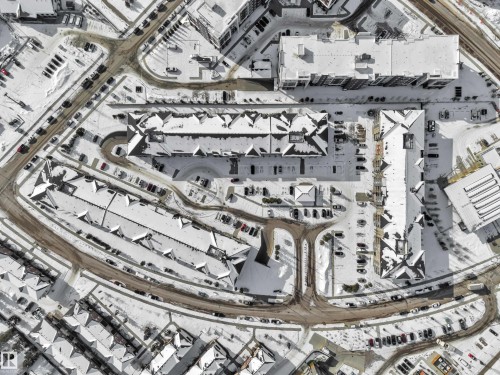 Aerial view of the property and surrounding neighborhood, featuring buildings with snow-covered roofs and visible roadways with parked vehicles - 415 12035 22 Avenue, Edmonton, AB - Other