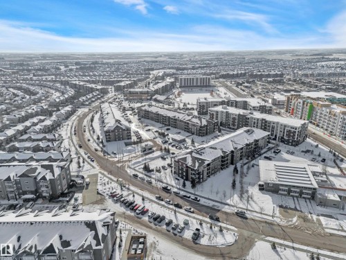 Aerial view showcasing a community with residential buildings and roads, all covered in a blanket of snow - 415 12035 22 Avenue, Edmonton, AB - Outdoor With View