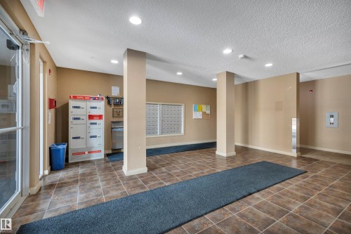 The entrance features tiled flooring, recessed lighting, and a mail area with individual mailboxes - 415 12035 22 Avenue, Edmonton, AB - Indoor