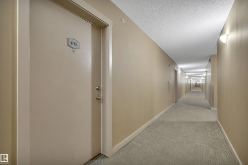 Entry door to the property, featuring a silver doorknob and a silver deadbolt - 415 12035 22 Avenue, Edmonton, AB - Indoor Photo Showing Other Room