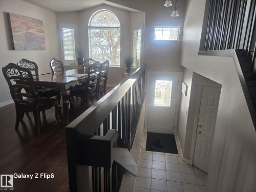 This property features an inviting entryway with tile flooring and a front door with a decorative glass insert - Edmonton, AB - Indoor Photo Showing Dining Room