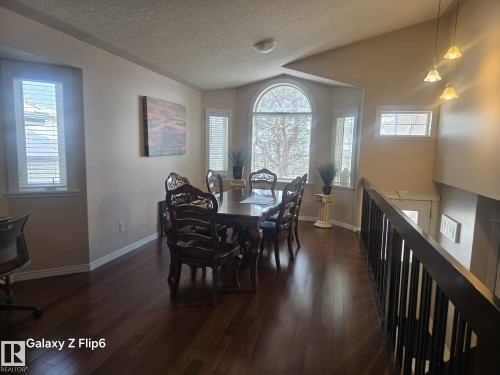 Dining area featuring hardwood floors and a large arched window providing natural light - Edmonton, AB - Indoor Photo Showing Dining Room