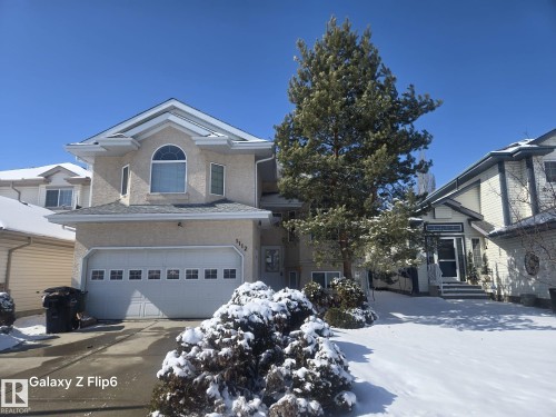 The property features a two-story exterior with stucco siding and a prominent arched window on the upper level - Edmonton, AB - Outdoor With Facade