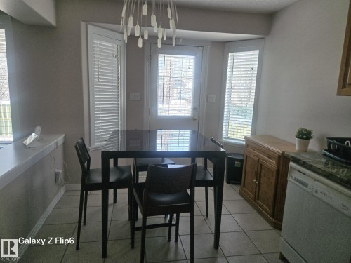 The dining area features bay windows with blinds and a tile floor - Edmonton, AB - Indoor Photo Showing Dining Room