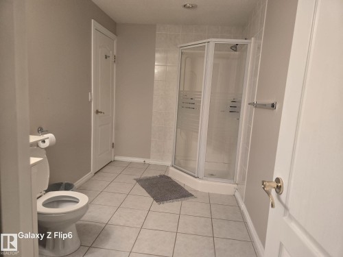 This bathroom features light-colored tile flooring and walls painted in a neutral tone - Edmonton, AB - Indoor Photo Showing Bathroom