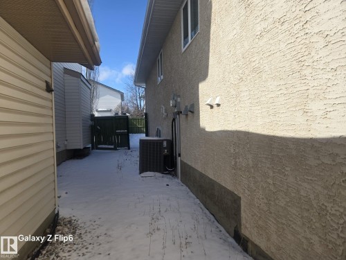 The exterior of the property features textured stucco siding and white framed windows - Edmonton, AB - Outdoor With Exterior