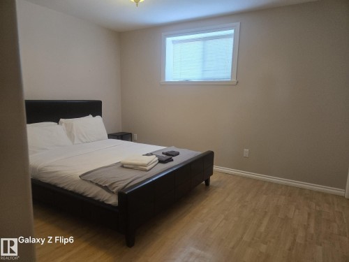 Bedroom featuring light-colored walls, a window with blinds, and light-toned flooring - Edmonton, AB - Indoor Photo Showing Bedroom