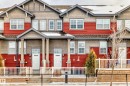 The property features a red and grey exterior with multiple windows and white doors - 86 4029 Orchards Drive, Edmonton, AB  - Outdoor With Facade 