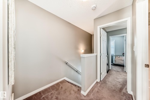 Carpeted hallway with painted walls and white trim - 86 4029 Orchards Drive, Edmonton, AB - Indoor Photo Showing Other Room
