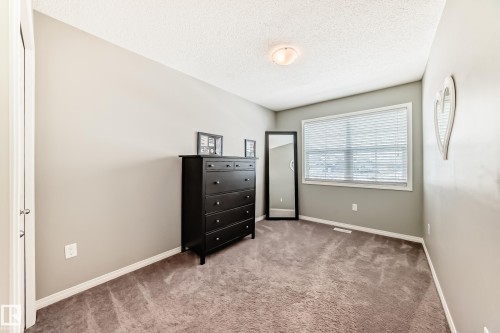 This room features a window with blinds, carpeted flooring, and neutral wall paint - 86 4029 Orchards Drive, Edmonton, AB - Indoor