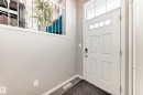 The property features a front entrance with a white paneled door, transom window, and tiled flooring - 86 4029 Orchards Drive, Edmonton, AB  - Indoor Photo Showing Other Room 