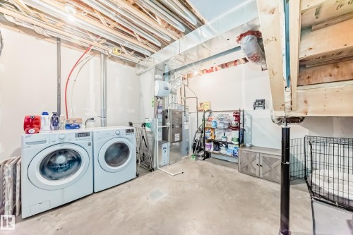 Laundry area featuring white appliances, exposed ceiling joists, and a concrete floor - 86 4029 Orchards Drive, Edmonton, AB - Indoor Photo Showing Laundry Room