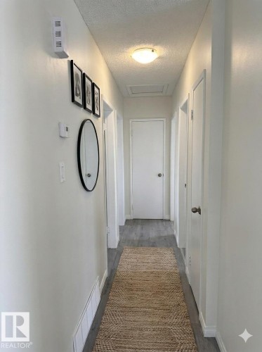 Well-lit hallway with light-toned walls and dark grey flooring - 13323 68 Street, Edmonton, AB - Indoor Photo Showing Other Room