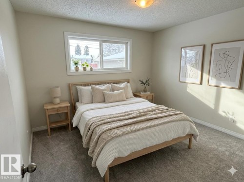 This bright room features a window providing natural light, warm white walls, and grey carpet flooring - 13323 68 Street, Edmonton, AB - Indoor Photo Showing Bedroom