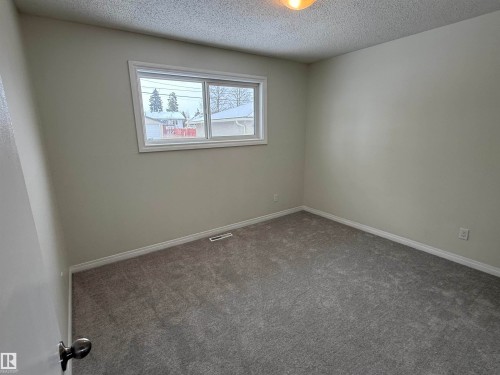 This room features light grey walls, a window with white trim, and grey carpet - 13323 68 Street, Edmonton, AB - Indoor Photo Showing Other Room