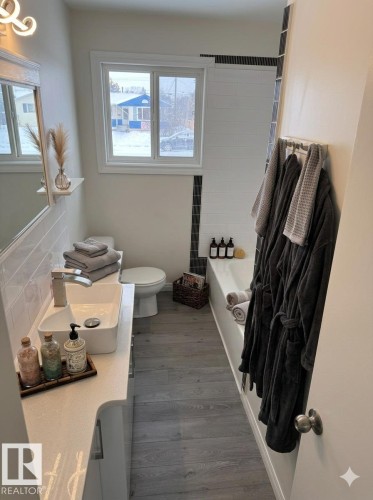 A bright bathroom featuring a vanity with a rectangular vessel sink and a window providing natural light - 13323 68 Street, Edmonton, AB - Indoor