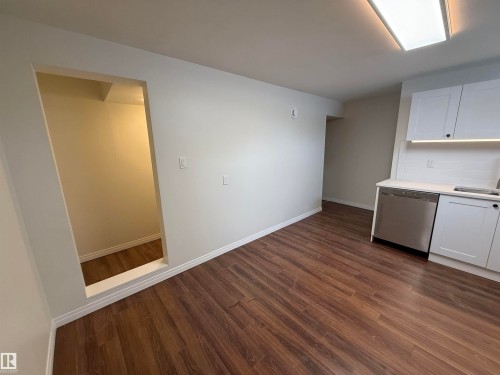 This space features wood-look flooring, white walls, and a recessed opening - 13323 68 Street, Edmonton, AB - Indoor