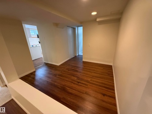 The property features wood-look flooring and light-colored walls throughout this area - 13323 68 Street, Edmonton, AB - Indoor Photo Showing Other Room