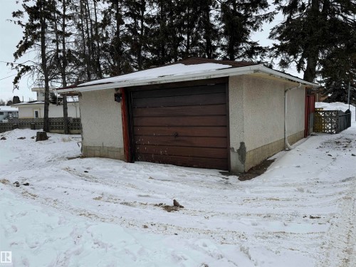 Detached garage with a brown garage door and white stucco exterior - 13323 68 Street, Edmonton, AB - Outdoor With Exterior