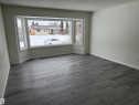 This room features expansive bay windows, white trim, and light-colored walls - 13323 68 Street, Edmonton, AB  - Indoor Photo Showing Other Room 