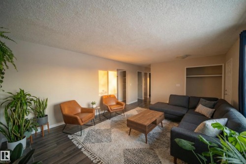 Living room featuring dark wood-style floors and a textured ceiling - 2311 146 Avenue, Edmonton, AB - Indoor Photo Showing Living Room