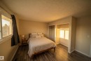Bedroom featuring multiple closets, a textured ceiling, and dark wood-type flooring - 2311 146 Avenue, Edmonton, AB  - Indoor Photo Showing Bedroom 